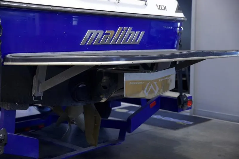 Slide: The Image of 2008 Malibu 21 VLX boat rear view with blue hull and logo. - 12