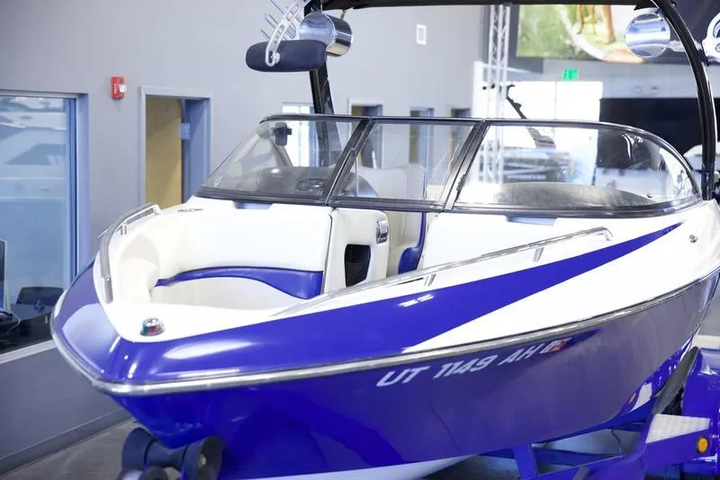 Slide: The Image of 2008 Malibu 21 VLX boat with blue and white design in showroom. - 2