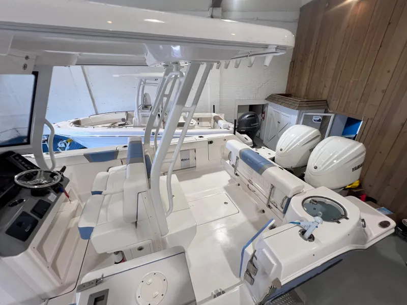 Slide: The Image of 2023 Robalo R 272 boat interior with dual engines in a showroom. - 10