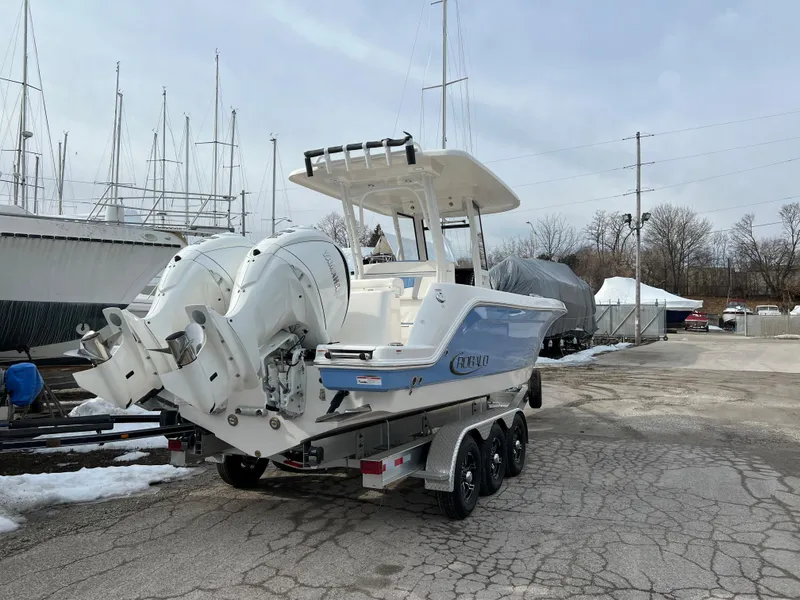 Slide: The Image of 2023 Robalo R 272 boat on trailer with dual engines in a marina setting. - 16