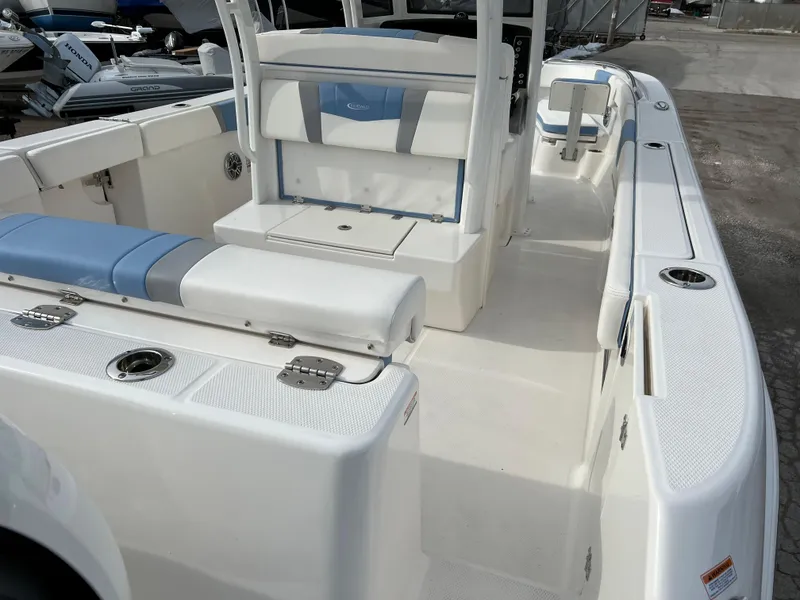 Slide: The Image of 2023 Robalo R 272 boat interior with white and blue seating, spacious deck. - 18