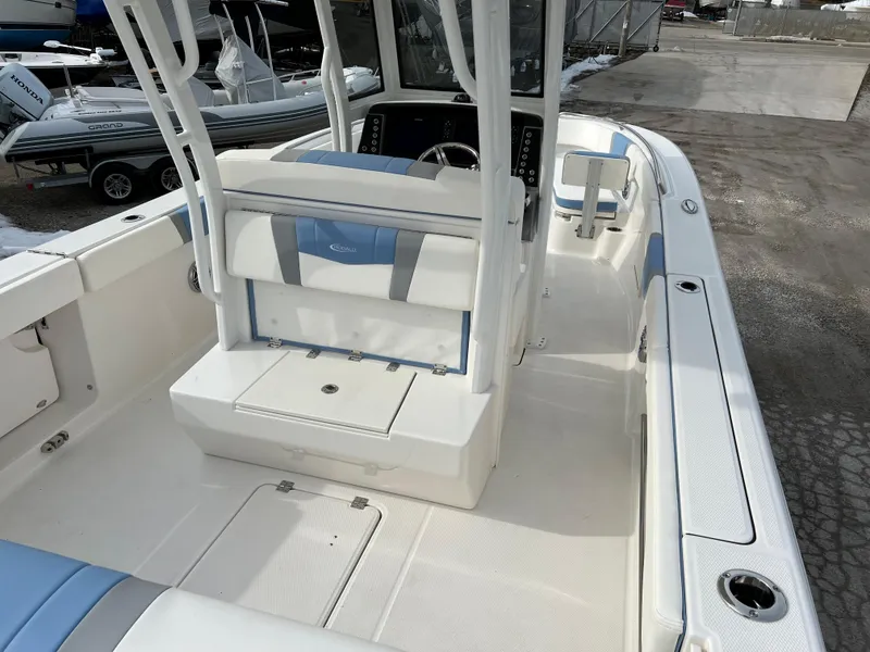 Slide: The Image of 2023 Robalo R 272 boat interior with white and blue seating, spacious deck. - 19