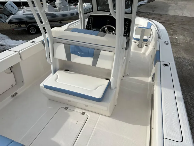Slide: The Image of 2023 Robalo R 272 boat interior with white and blue seating, modern helm, and spacious deck. - 20