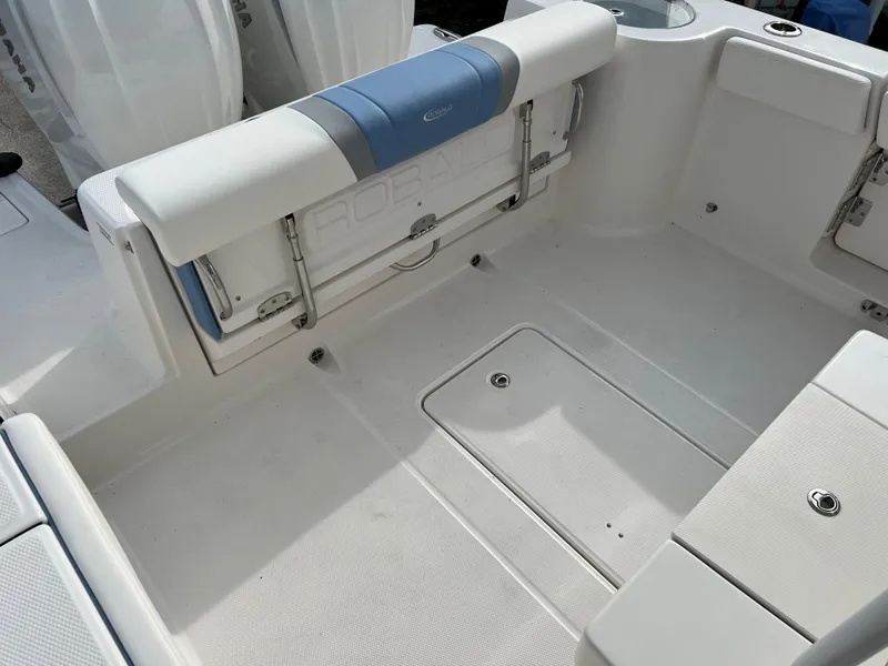 Slide: The Image of 2023 Robalo R 272 boat interior with white seating and storage compartments. - 21