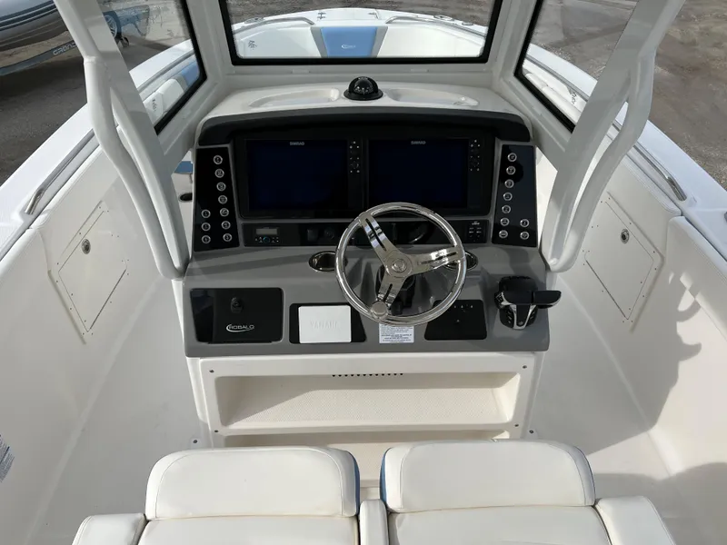 Slide: The Image of 2023 Robalo R 272 boat cockpit with dual screens and steering wheel. - 23