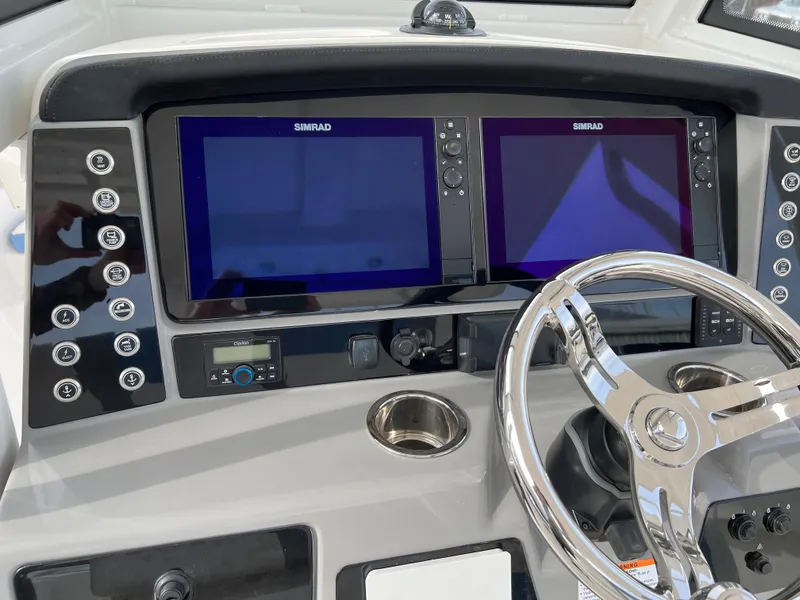 Slide: The Image of 2023 Robalo R 272 boat dashboard with dual Simrad displays and steering wheel. - 25