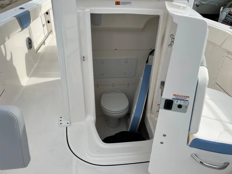 Slide: The Image of 2023 Robalo R 272 boat interior with compact marine toilet. - 28