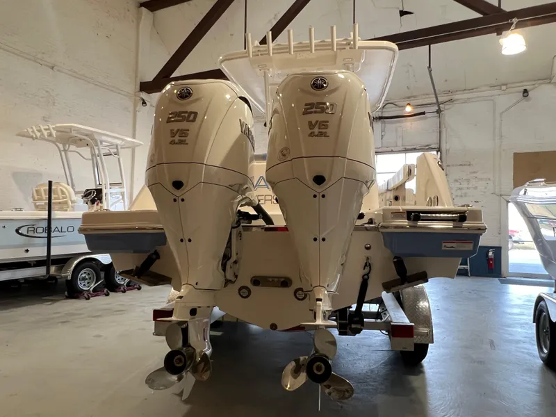 Slide: The Image of 2023 Robalo R 272 boat with dual 250 V6 engines in a warehouse. - 6