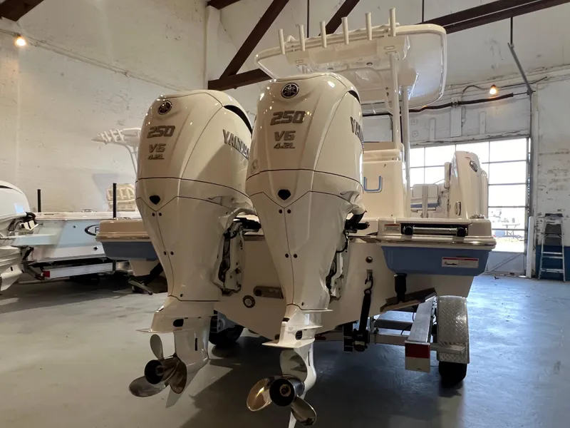 Slide: The Image of 2023 Robalo R 272 boat with twin Yamaha 250 V6 engines in a showroom. - 7