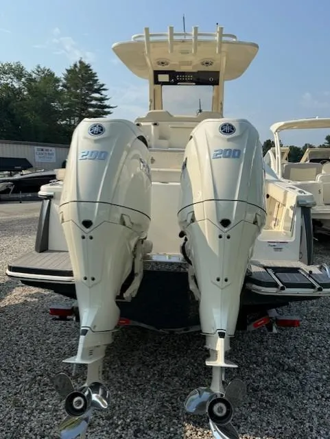 Slide: The Image of 2025 Scout 260 LXF boat with dual 200 horsepower engines, parked on gravel. - 11