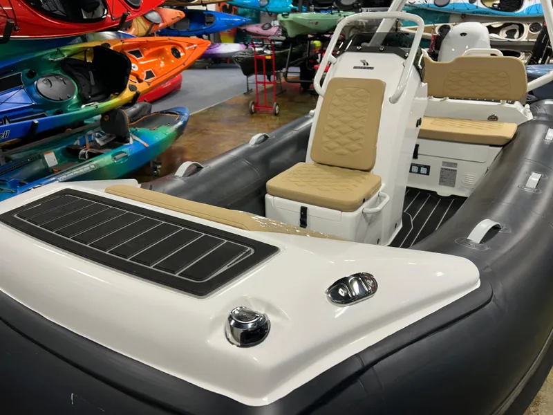 Slide: The Image of 2025 Highfield Sport 390 inflatable boat with beige seating, displayed among colorful kayaks. - 14