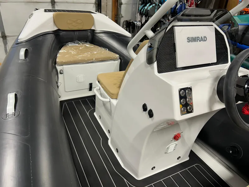 Slide: The Image of 2025 Highfield Sport 390 boat interior with Simrad navigation system and cushioned seating. - 17