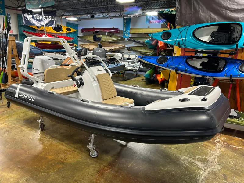 Slide: The Image of 2025 Highfield Sport 390 inflatable boat displayed in a showroom with kayaks. - 2