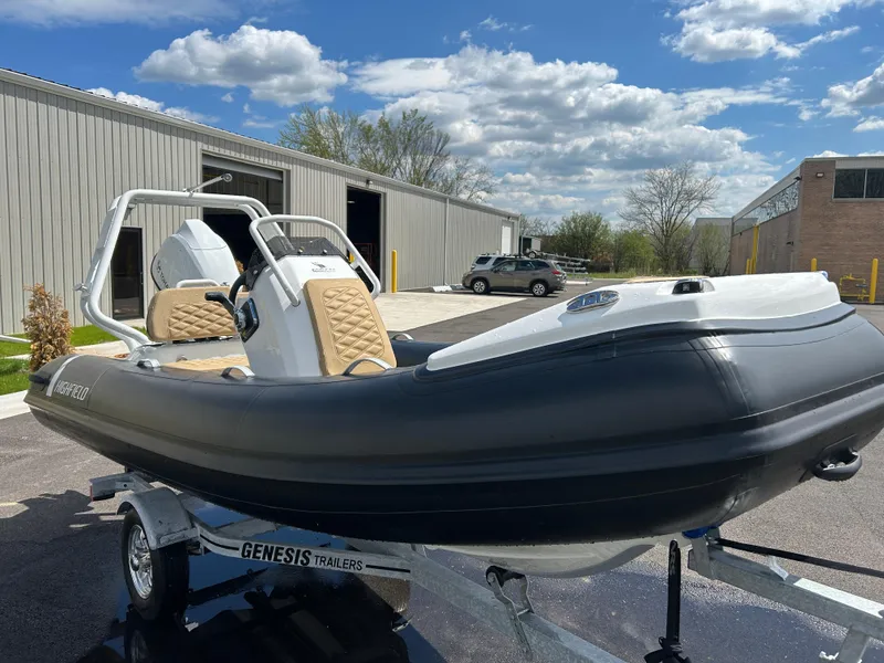 Slide: The Image of 2025 Highfield Sport 390 boat on trailer, parked outdoors under a cloudy sky. - 20