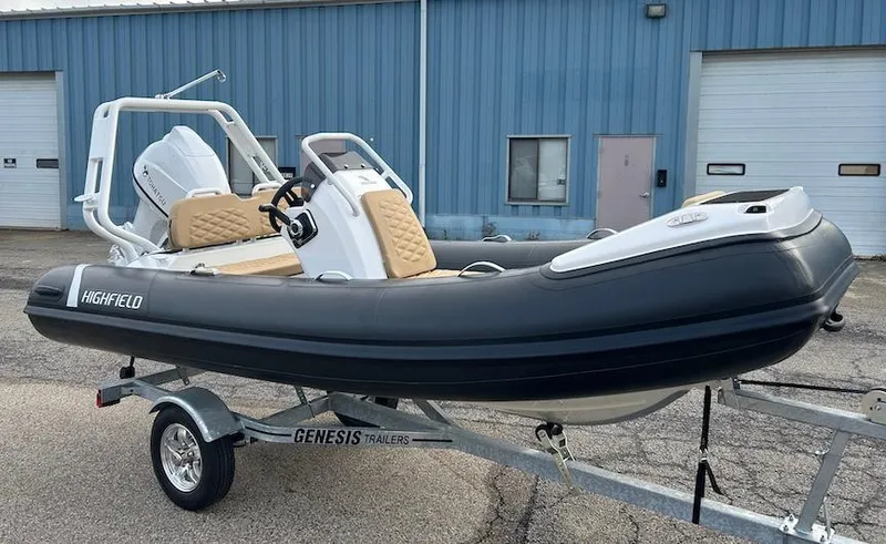 Slide: The Image of 2025 Highfield Sport 390 inflatable boat on Genesis trailer, parked outside industrial building. - 3