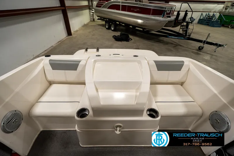 Slide: The Image of 2013 Bayliner 175 boat interior with seating and cup holders in a showroom. - 14