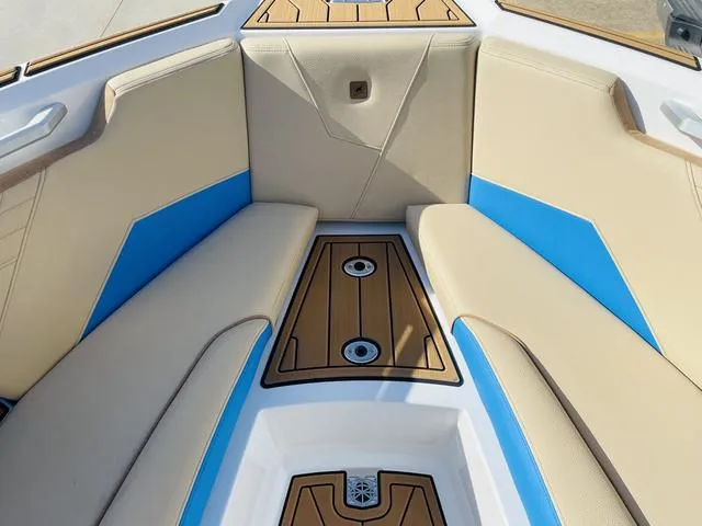 Slide: The Image of 2024 Nautique S23 boat interior with tan and blue seating. - 16