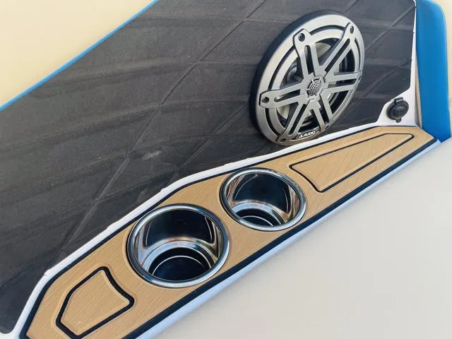 Slide: The Image of 2024 Nautique S23 boat interior with speaker and cup holders. - 20