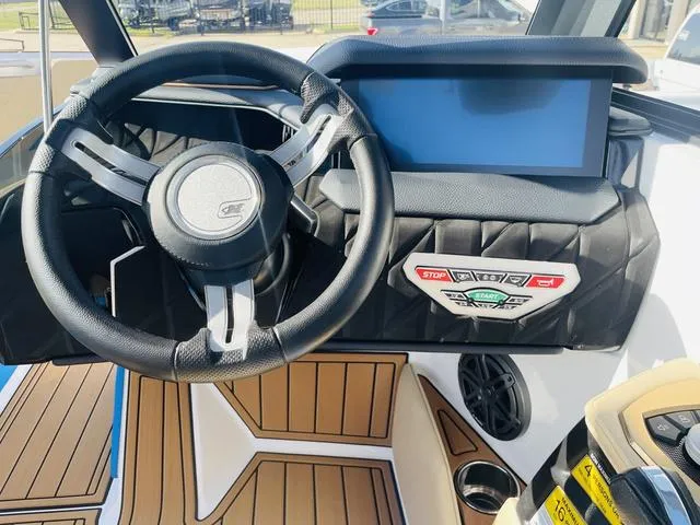 Slide: The Image of 2024 Nautique S23 boat dashboard with steering wheel and digital display. - 24