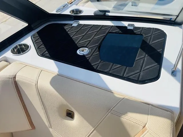 Slide: The Image of 2024 Nautique S23 boat interior with quilted black panel and beige seating. - 27
