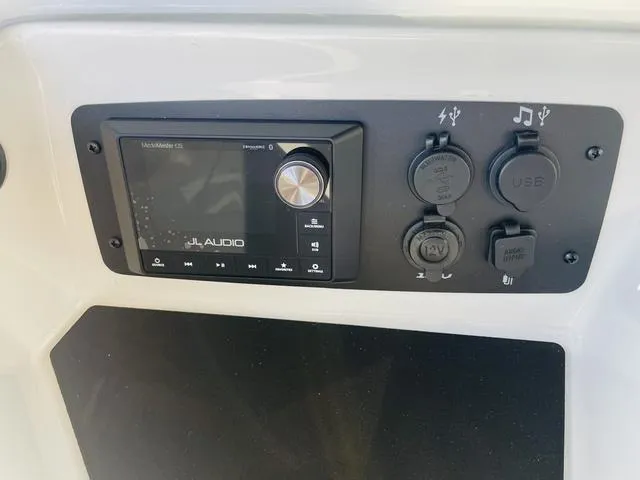 Slide: The Image of 2024 Nautique S23 audio control panel with JL Audio system and power outlets. - 29