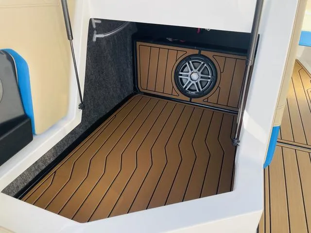 Slide: The Image of 2024 Nautique S23 boat interior with teak flooring and speaker system. - 31