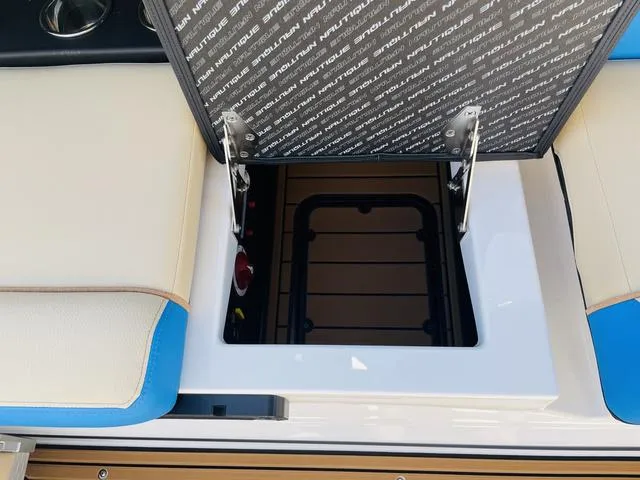 Slide: The Image of 2024 Nautique S23 boat storage compartment with open hatch, showcasing interior details. - 35