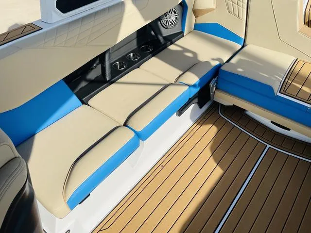 Slide: The Image of 2024 Nautique S23 boat interior with beige and blue seating, teak flooring. - 38