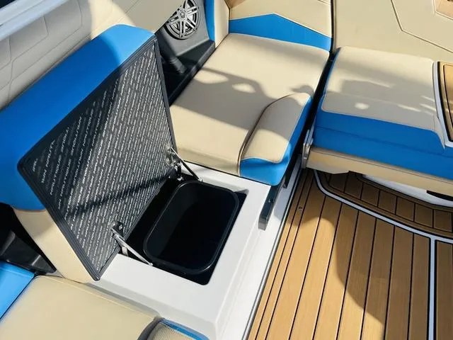 Slide: The Image of 2024 Nautique S23 boat interior with open storage compartment and cushioned seating. - 41