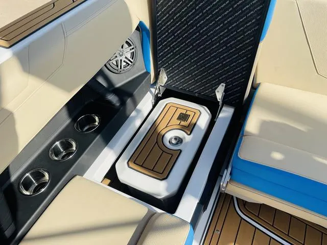 Slide: The Image of 2024 Nautique S23 boat interior with cup holders and storage compartment. - 42