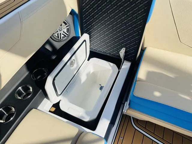 Slide: The Image of 2024 Nautique S23 boat interior with open storage compartment and cup holders. - 43