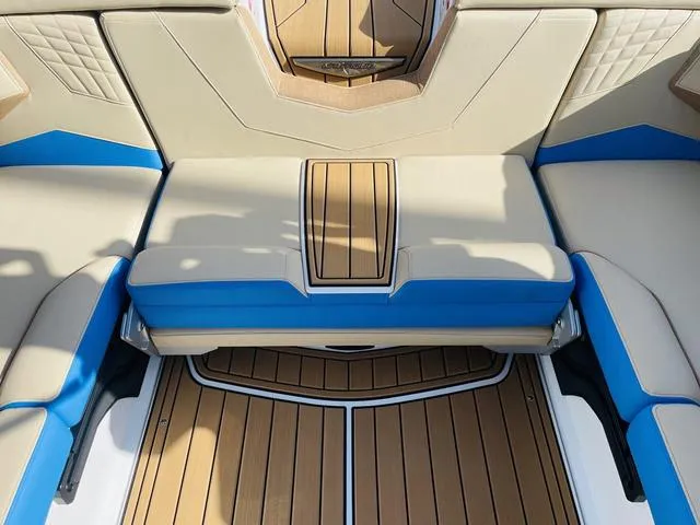 Slide: The Image of 2024 Nautique S23 boat interior with tan and blue seating, teak flooring. - 44