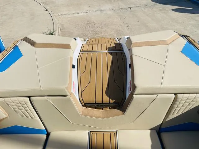 Slide: The Image of 2024 Nautique S23 boat interior with tan and blue upholstery. - 47