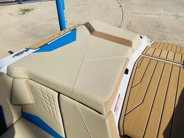 Slide: The Image of 2024 Nautique S23 boat interior with tan and blue upholstery. - 48