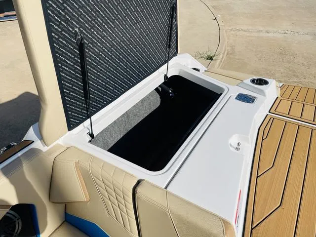 Slide: The Image of 2024 Nautique S23 boat storage compartment with beige seating and teak flooring. - 49