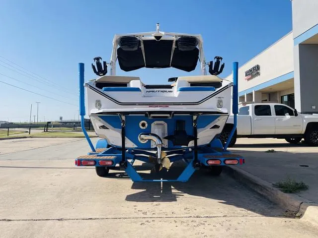 Slide: The Image of 2024 Nautique S23 boat on trailer, rear view, parked outdoors. - 7