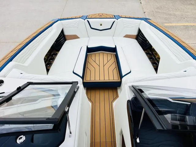Slide: The Image of 2025 Nautique SUPER AIR G G25 boat interior with sleek seating and wood accents. - 12