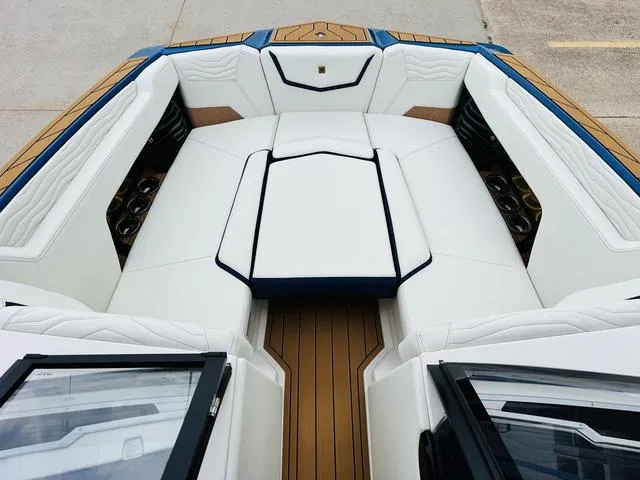 Slide: The Image of 2025 Nautique SUPER AIR G G25 boat interior with white seating and wood accents. - 13