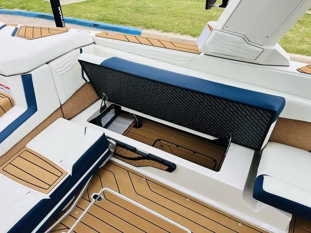 Slide: The Image of 2025 Nautique SUPER AIR G G25 interior with open storage compartment, featuring sleek seating and wood accents. - 14