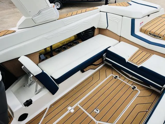 Slide: The Image of 2025 Nautique SUPER AIR G G25 boat interior with luxurious seating and teak flooring. - 17