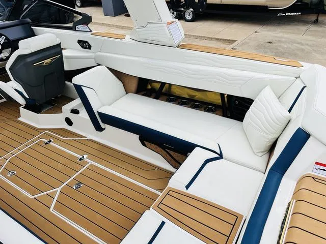 Slide: The Image of 2025 Nautique SUPER AIR G G25 interior with white and tan seating, modern design. - 18