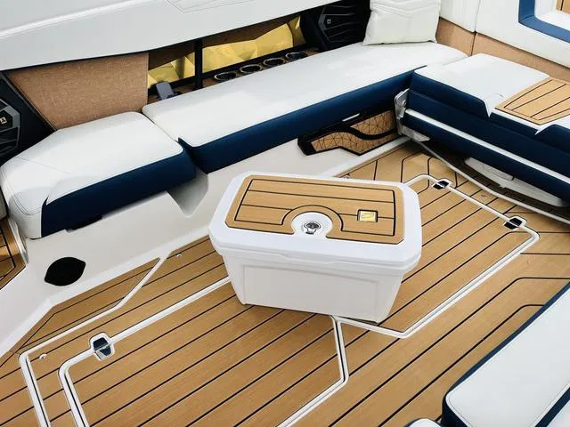 Slide: The Image of 2025 Nautique SUPER AIR G G25 boat interior with cushioned seating and teak flooring. - 27