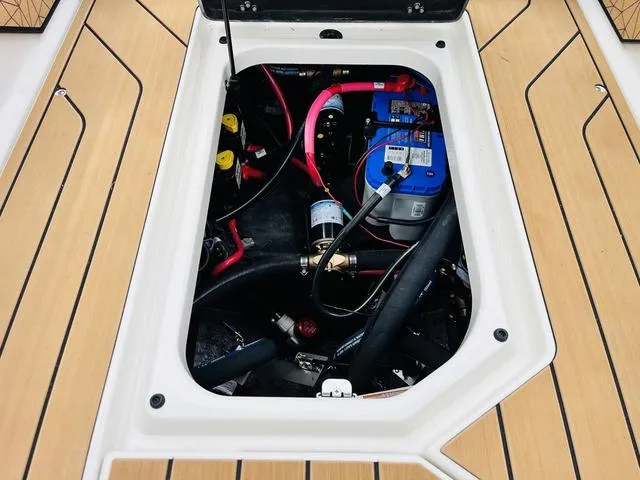 Slide: The Image of 2025 Nautique SUPER AIR G G25 engine compartment with battery and wiring. - 30