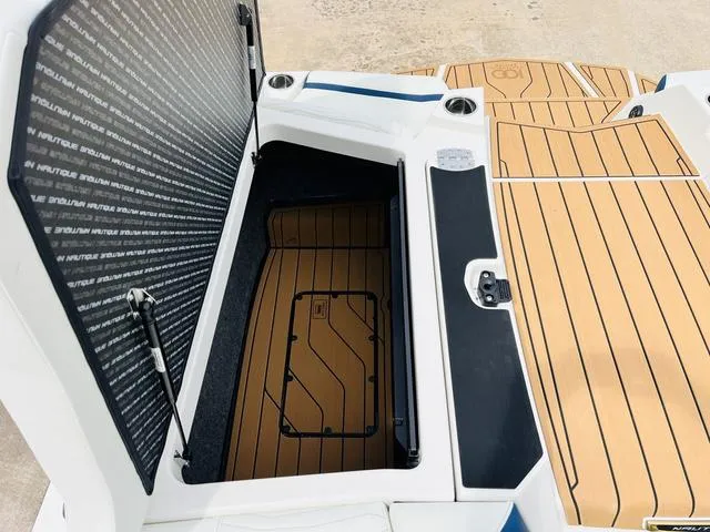 Slide: The Image of 2025 Nautique SUPER AIR G G25 boat storage compartment with teak flooring. - 33