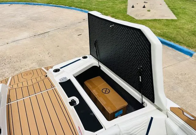 Slide: The Image of 2025 Nautique SUPER AIR G G25 boat storage compartment open with a box inside. - 34