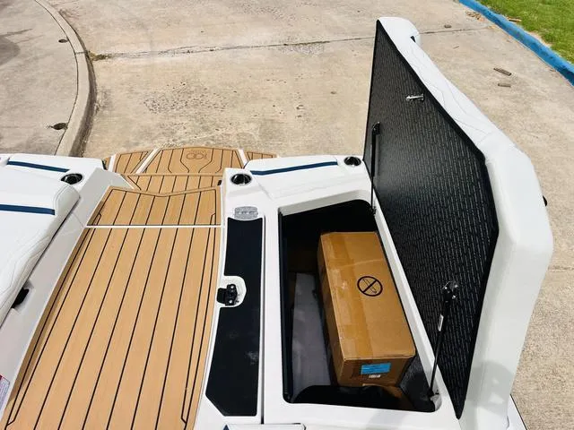 Slide: The Image of 2025 Nautique SUPER AIR G G25 boat storage compartment with a cardboard box. - 35