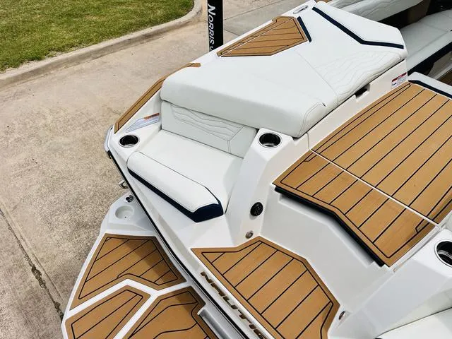 Slide: The Image of 2025 Nautique SUPER AIR G G25 boat with sleek deck design and cushioned seating. - 39