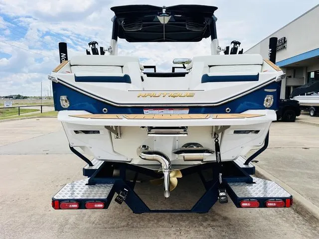 Slide: The Image of 2025 Nautique SUPER AIR G G25 boat rear view at a marina. - 7