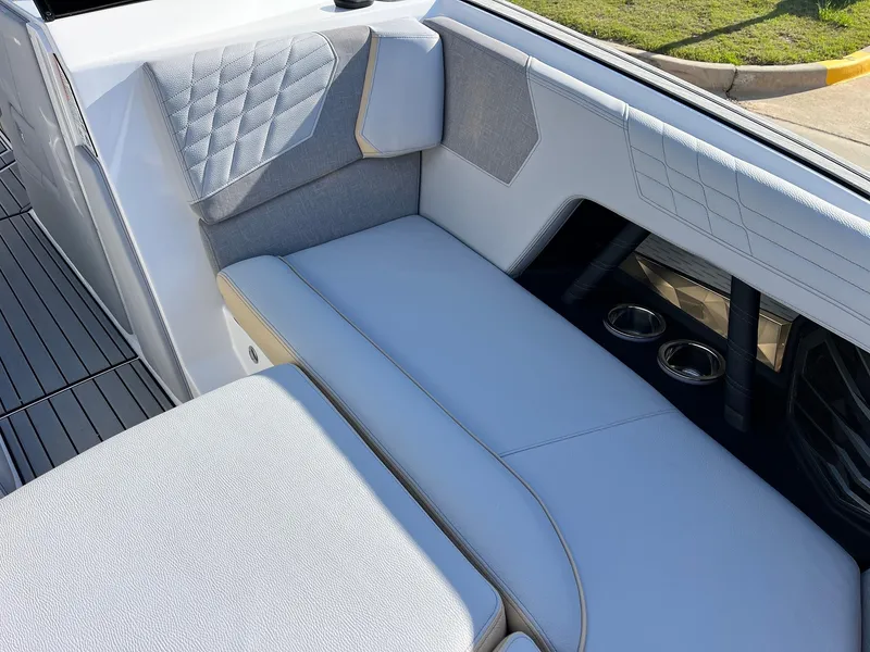 Slide: The Image of 2024 Nautique G25 boat interior with gray seating and cup holders. - 23