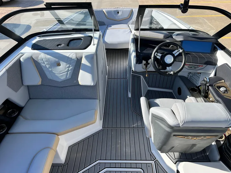 Slide: The Image of 2024 Nautique G25 boat interior with modern seating and sleek dashboard design. - 25